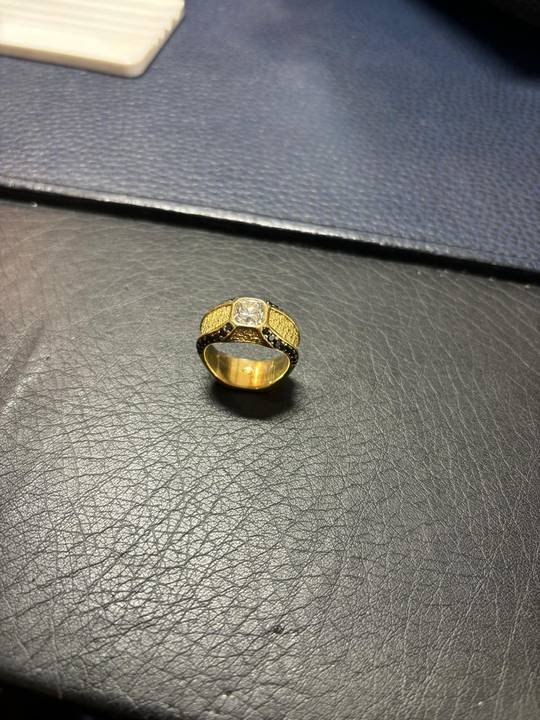 Bague en or posée sur un cuir sombre