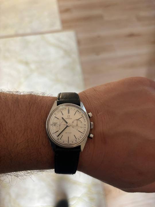 Montre chronographe ancienne à cadran crème portée au poignet